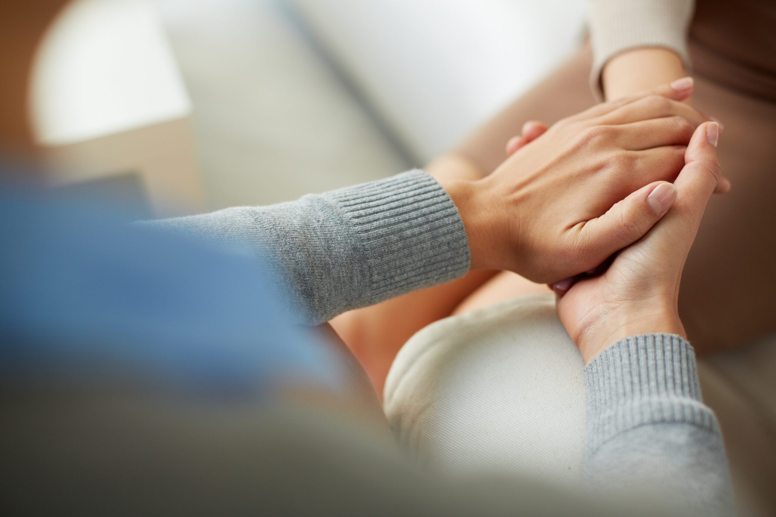 Two hands clasped together, conveying support and connection